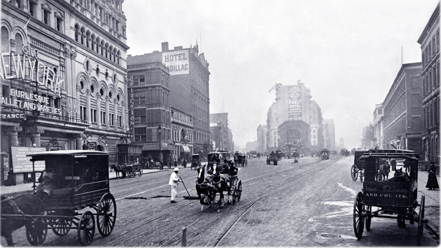 Vintage streets of Times Square with early automobiles and tall buildings.