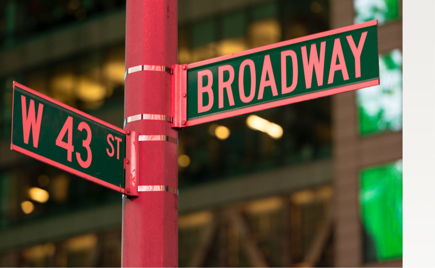 Street sign indicating Broadway with a blurred building background